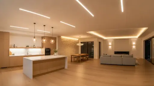 Modern open-plan kitchen and living area with wooden floors, pendant lighting, and minimalist furniture