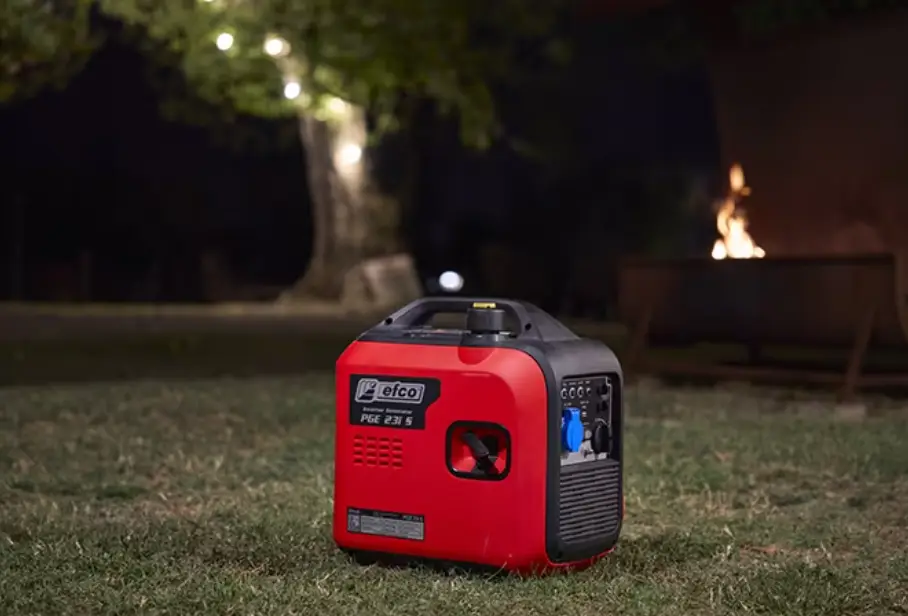 Portable red generator on grass at night with fire pit and tree lights in background