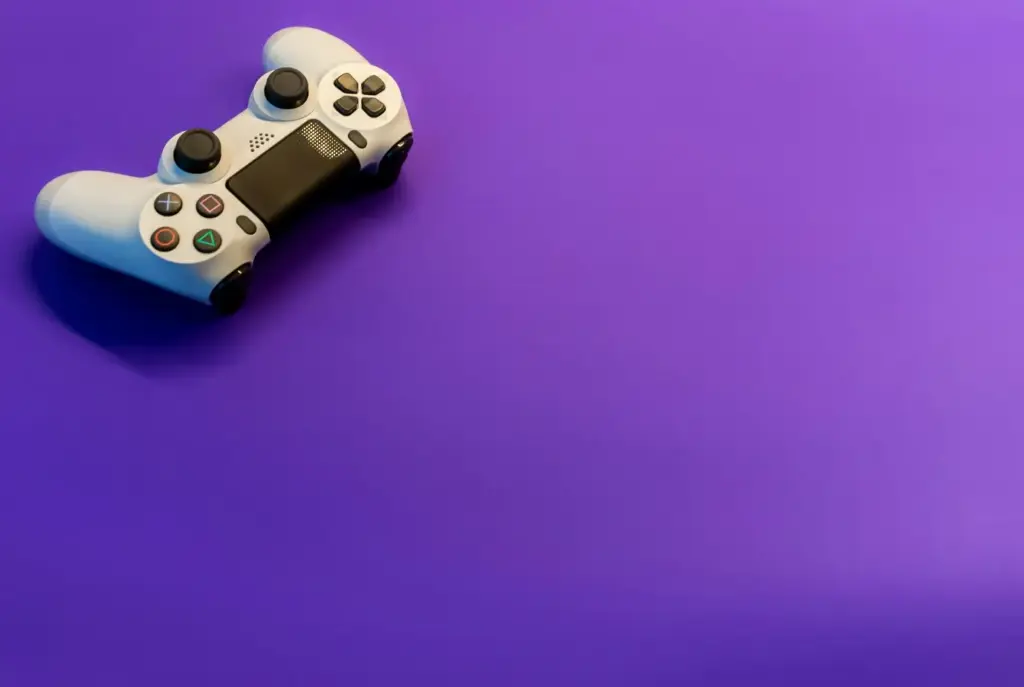 White gaming controller on vibrant purple background