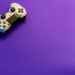 White gaming controller on vibrant purple background