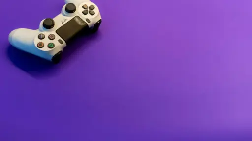 White gaming controller on vibrant purple background