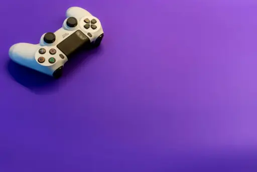 White gaming controller on vibrant purple background