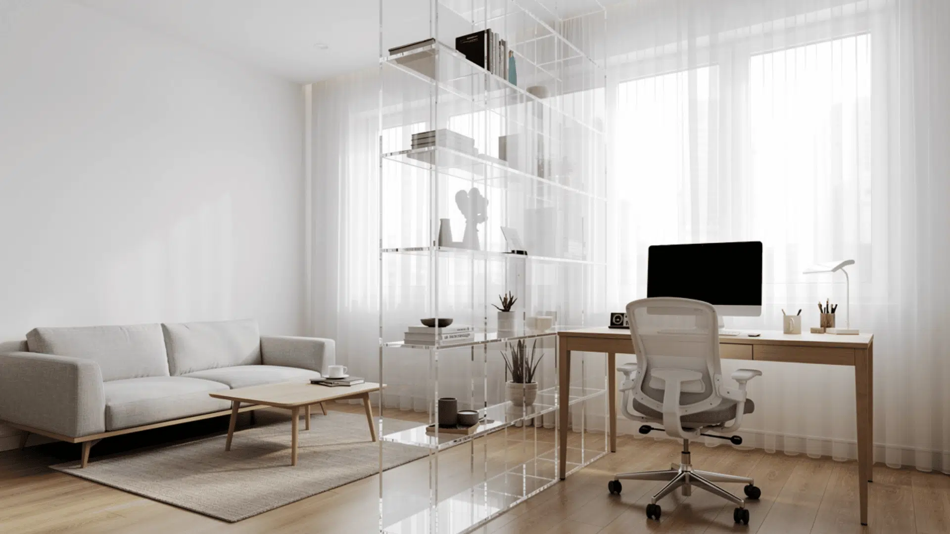 _a bright open plan apartment with a grey sofa and a transparent acrylic shelving unit dividing the living area from a home office with a computer desk