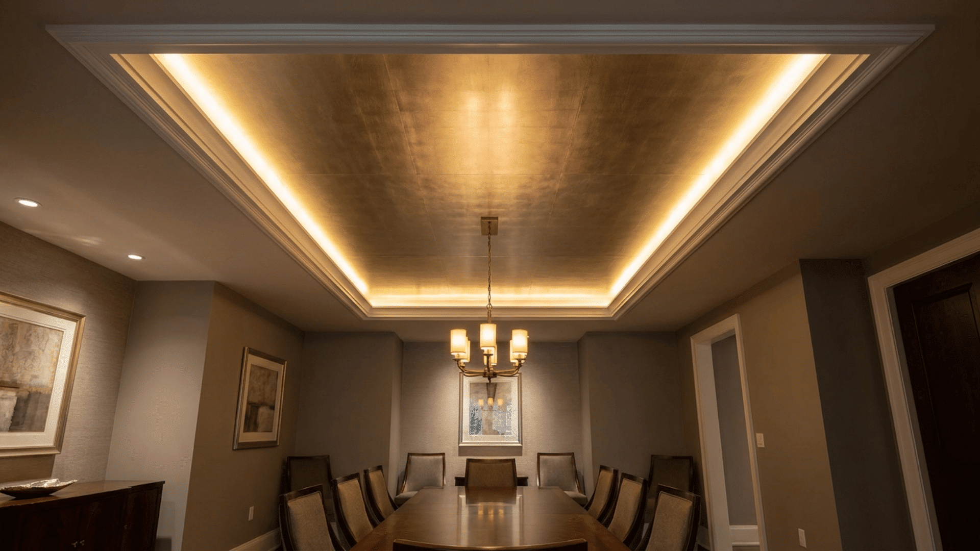 A dining room with central metallic ceiling panel in brushed gold, framed by matte white ceiling.