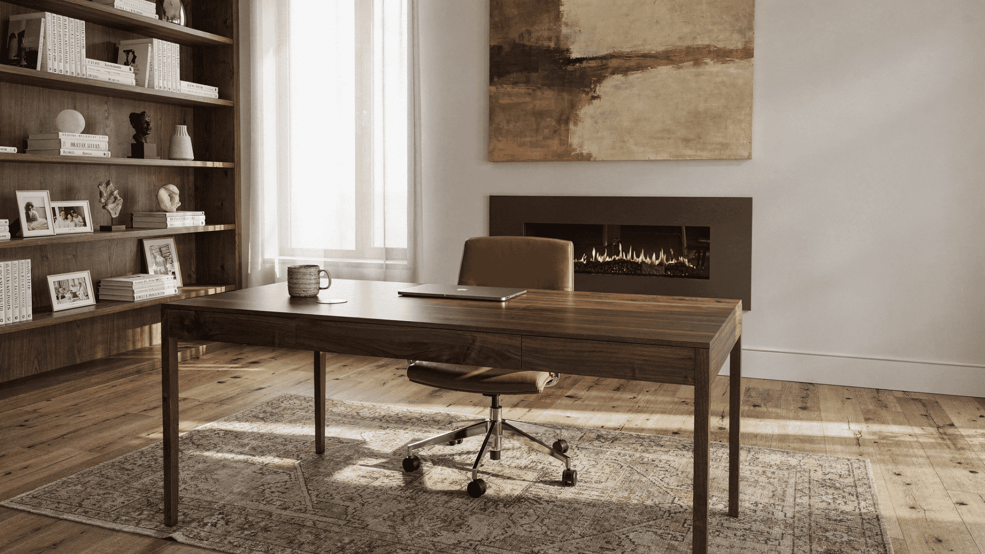 a modern home office with a wooden desk a leather chair bookshelves a fireplace and artwork above the fireplace
