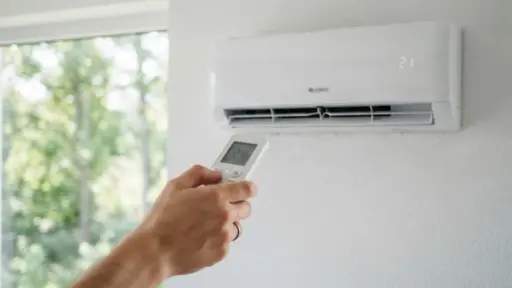 hand holding remote control to adjust wall-mounted air conditioner set to 21 degrees