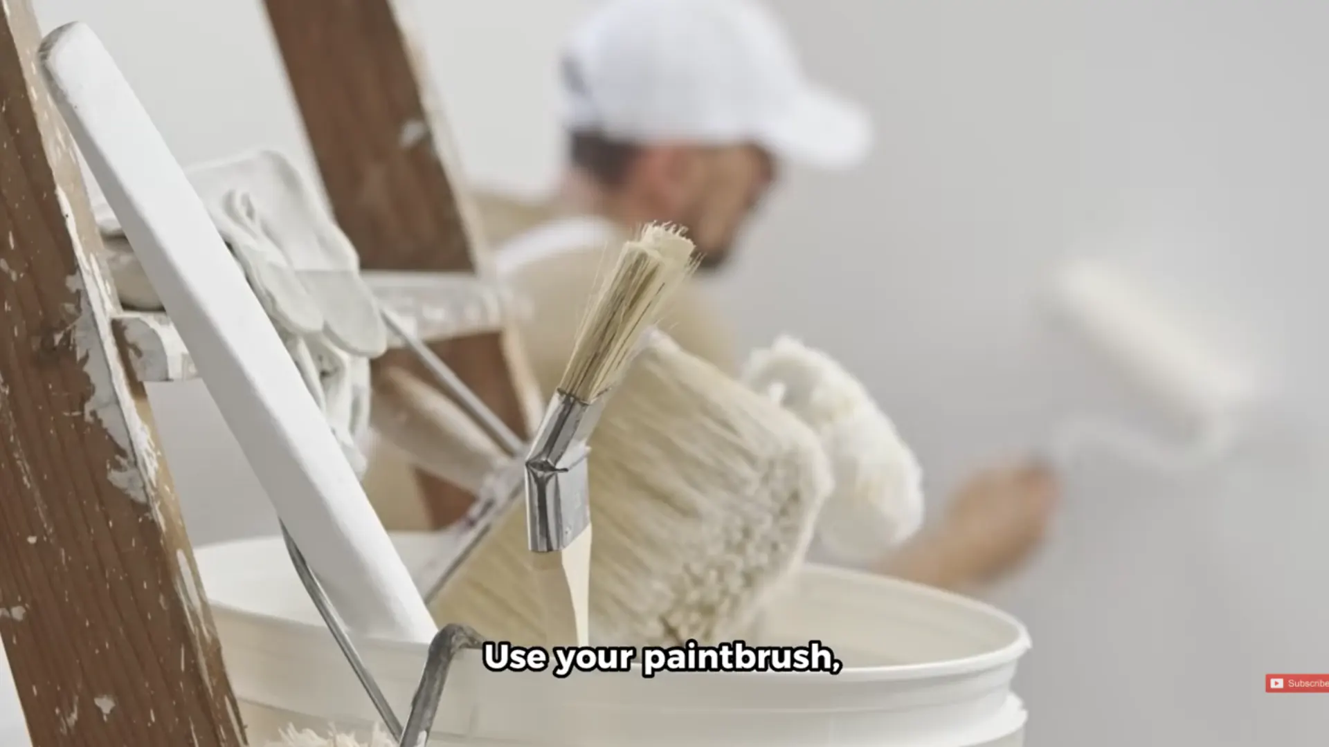 paintbrushes resting in a paint bucket while preparing to paint garage door grooves and edges