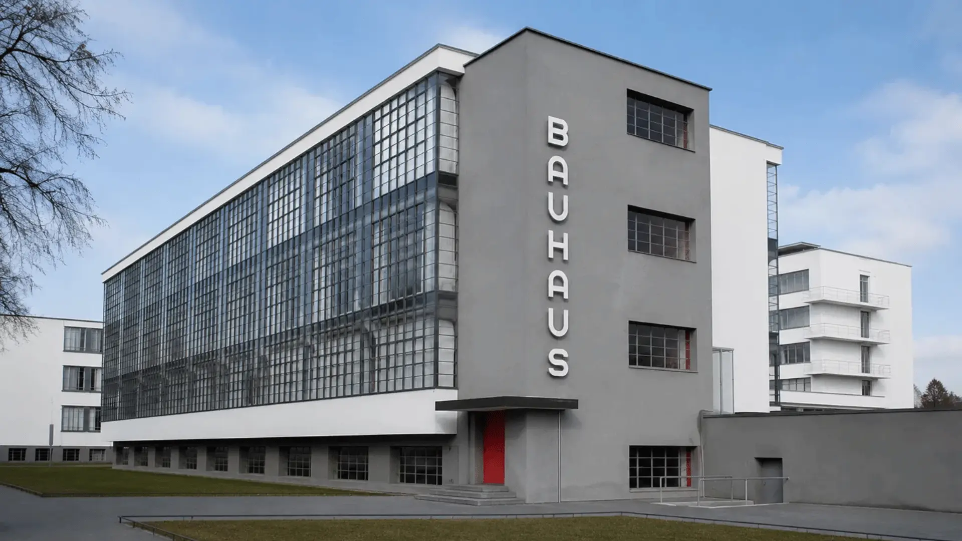 bauhaus building with a glass curtain wall and bold vertical signage lettering