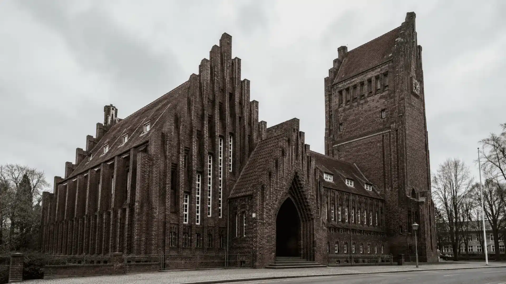 brick expressionist church with jagged ribbed facade pointed arches and a tall clock tower