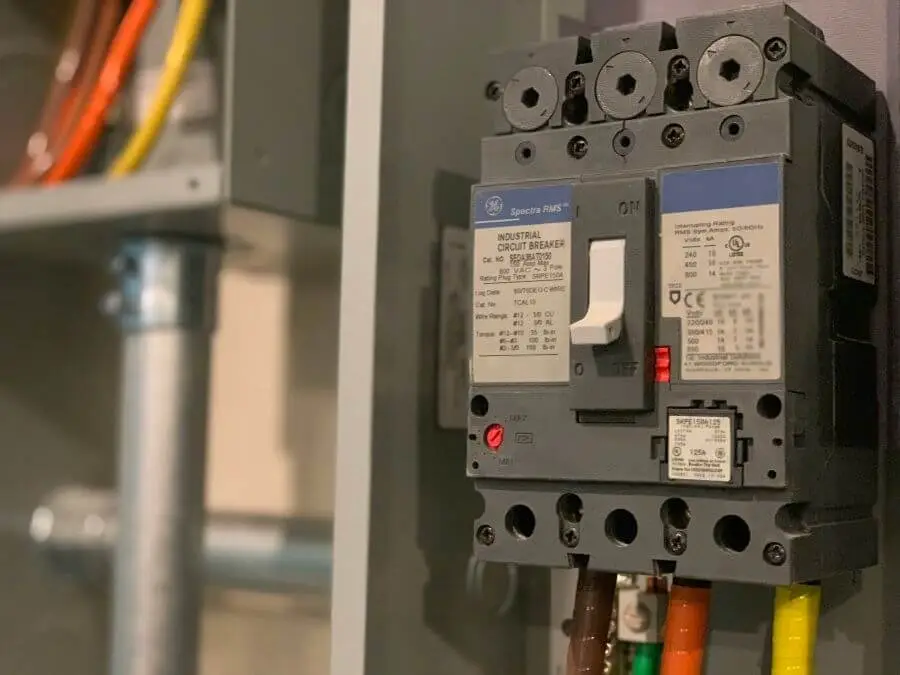 Industrial circuit breaker with visible wiring in a dimly lit electrical panel