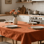 dining table set with place settings and a vase of flowers and a kitchen in the background