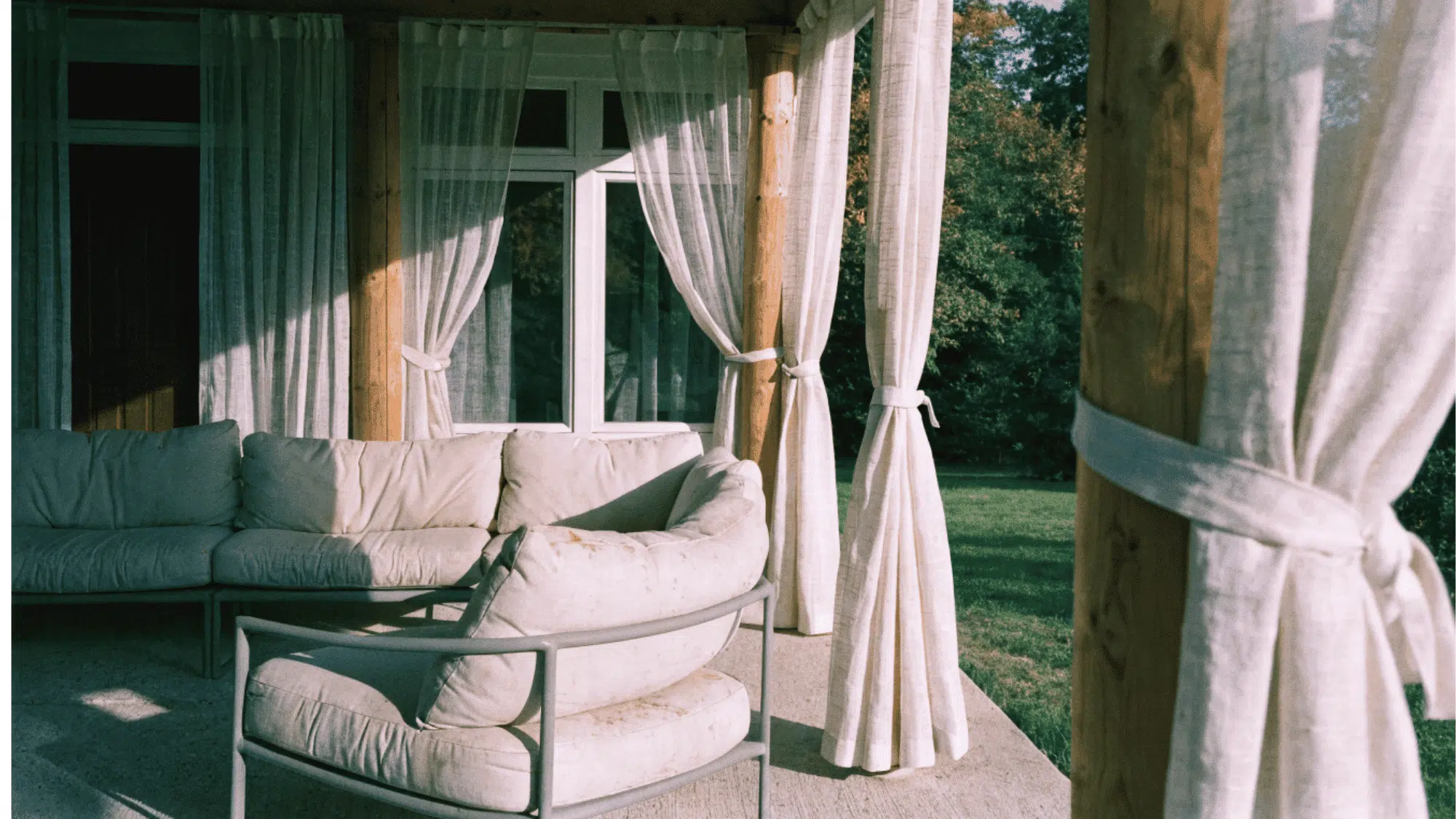 fashionable outdoor curtains on a modern suburban porch with contemporary seating in warm afternoon light