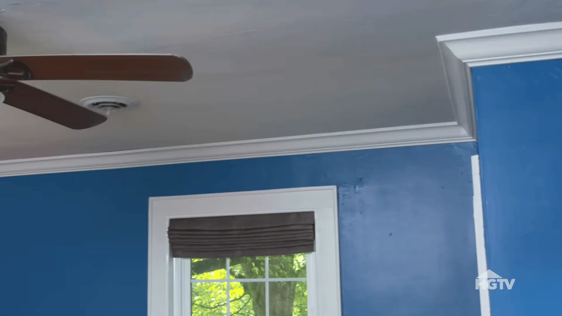 installer securing crown molding with a nail gun and applying paintable caulk for a smooth finished appearance