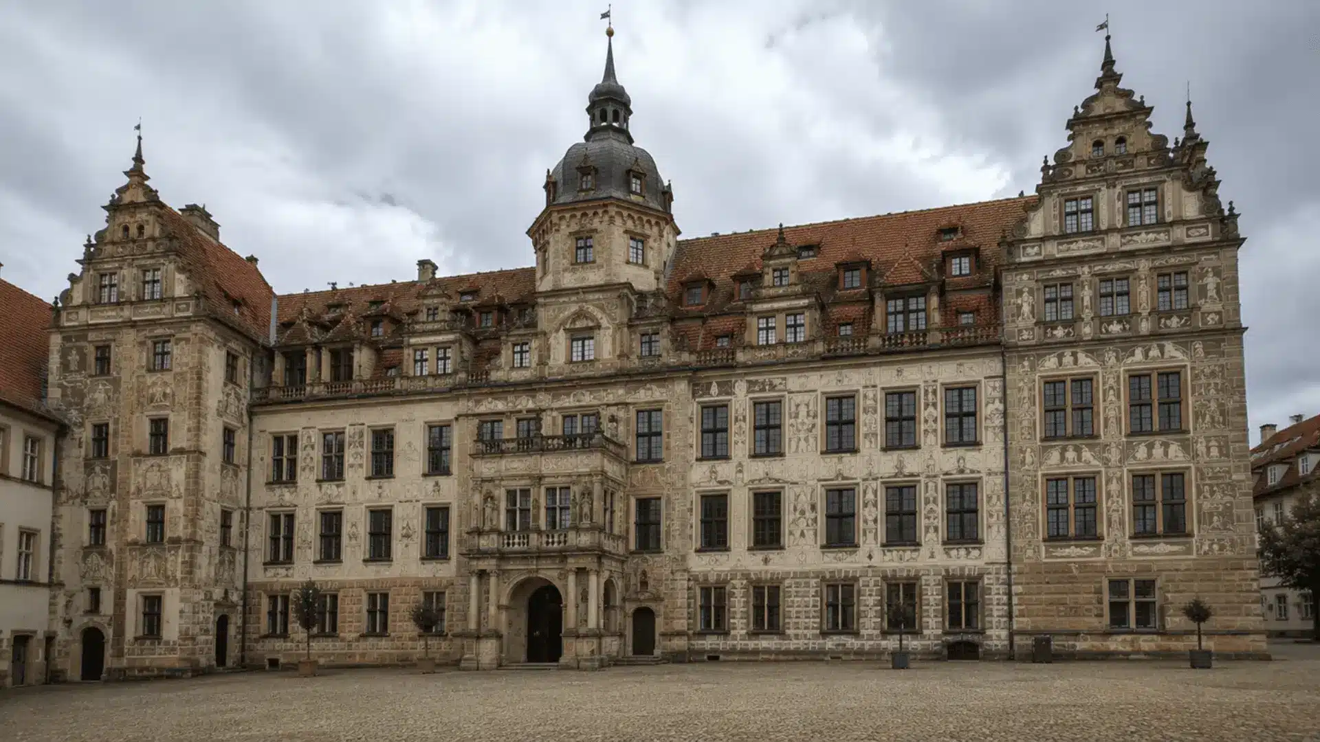 german renaissance castle facade with ornate stepped gables painted panels and a central tower