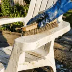 hand scrubbing outdoor chair with brush and soapy water