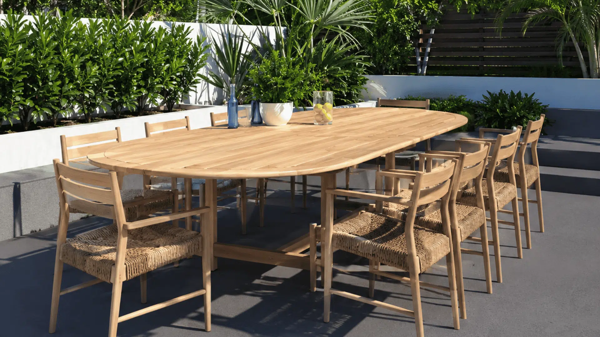 large wooden outdoor dining table with matching chairs arranged on sunny modern backyard patio