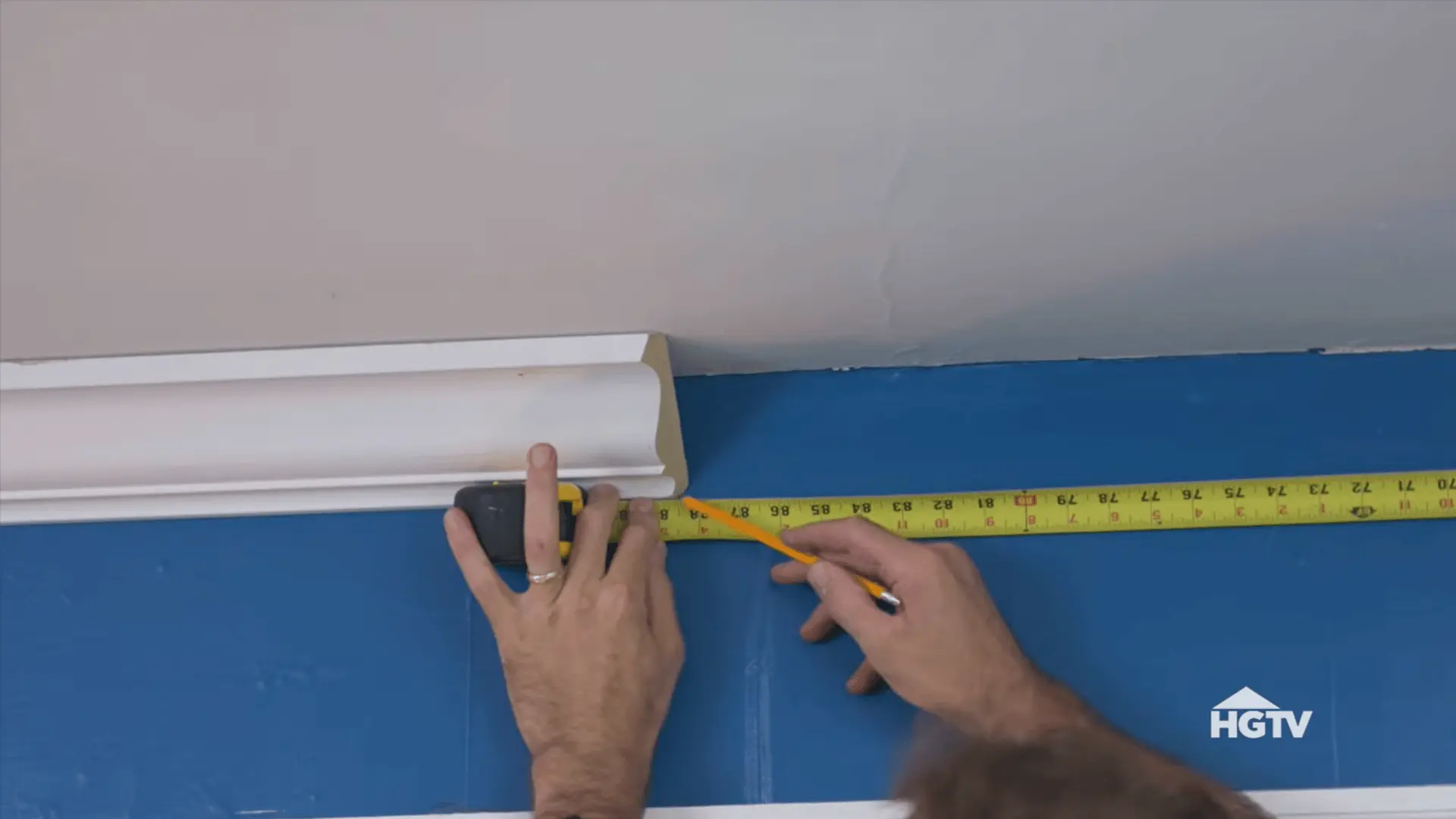 two crown molding boards cut with matching scarf joint angles ready to create a seamless connection on a long wall