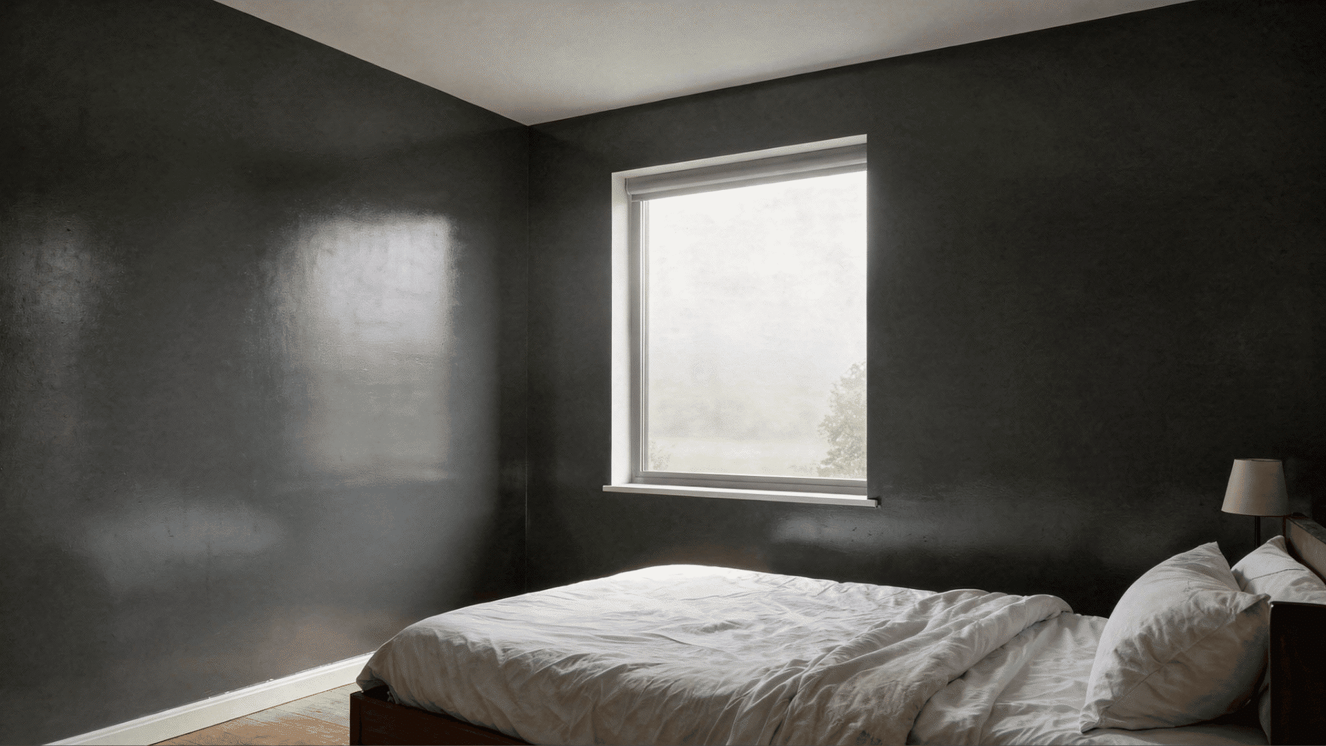 modern bedroom with a made bed covered in white linen a window with a view of trees and a bedside lamp with satin finish