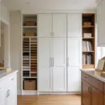modern kitchen with white and wood cabinets and material samples on counters