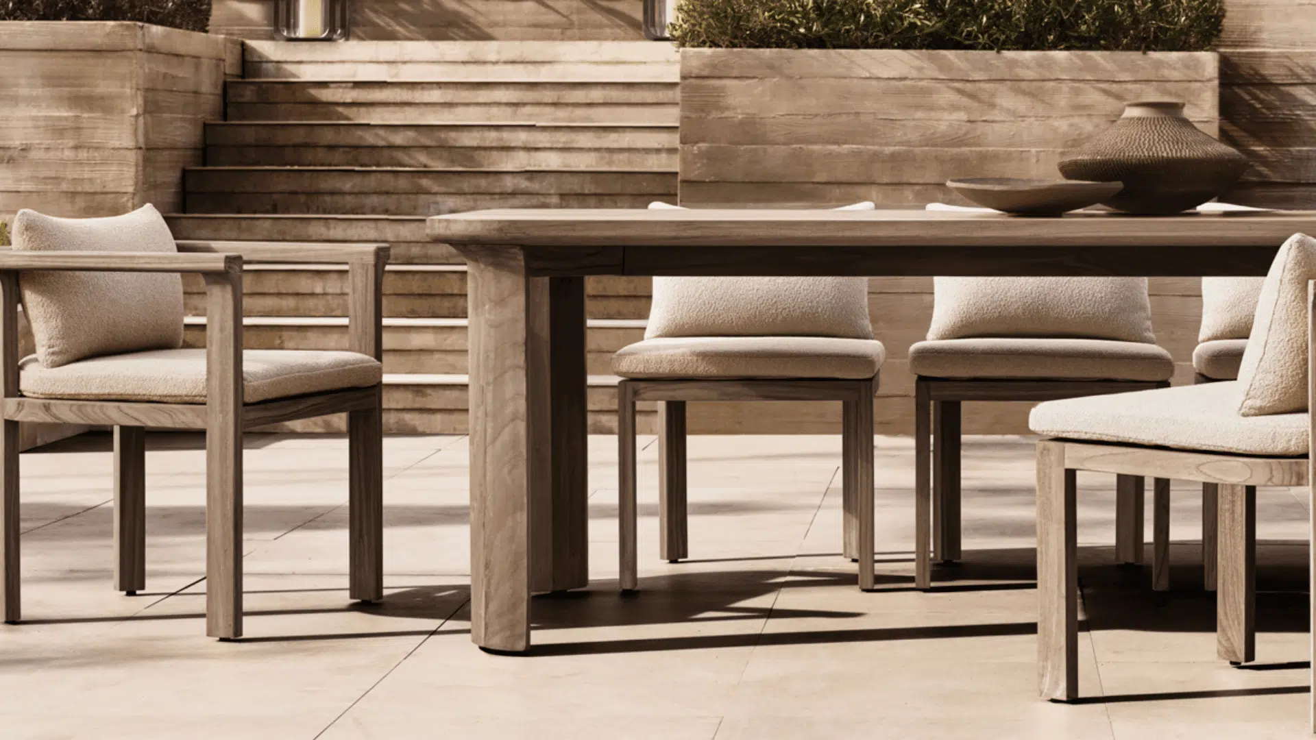 modern wooden outdoor dining set with cushioned chairs arranged on elegant stone terrace patio