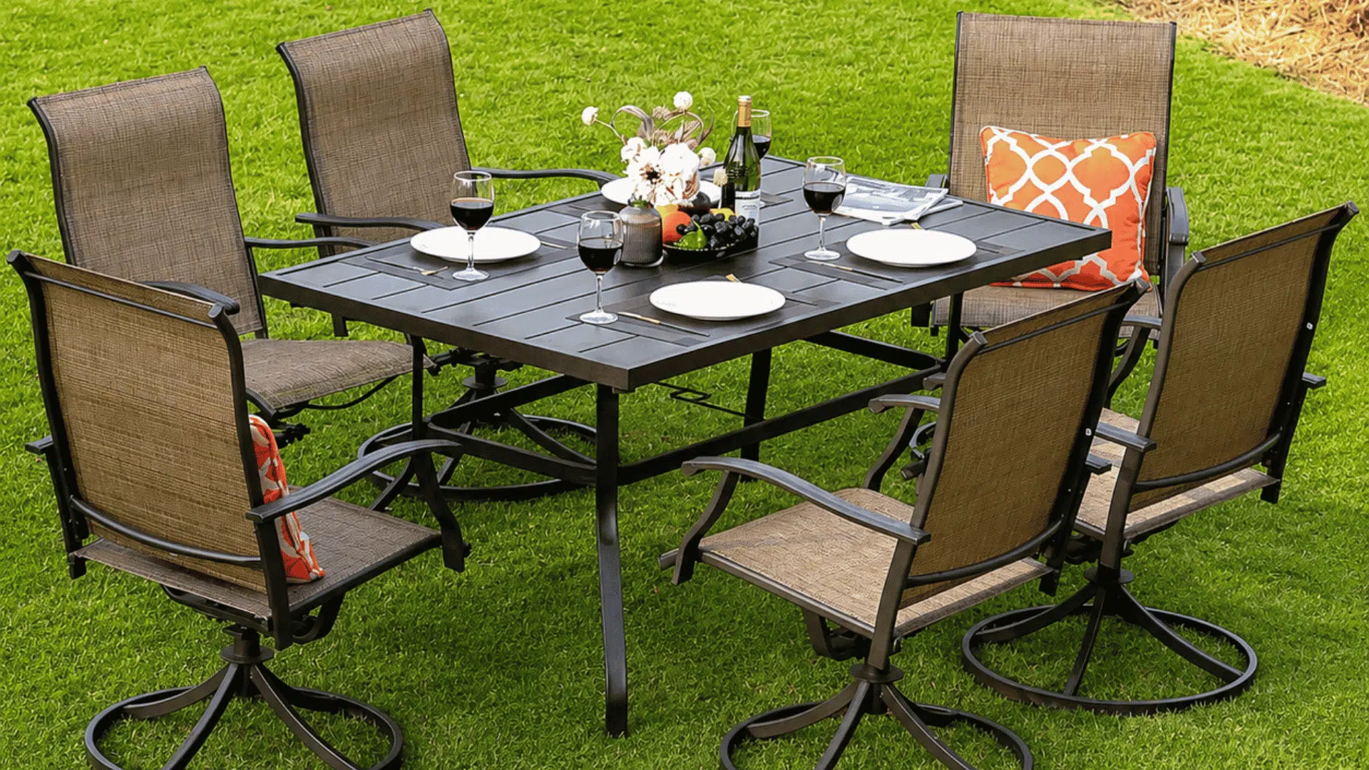 outdoor patio dining set with six swivel chairs and table setup on green lawn in sunny backyard