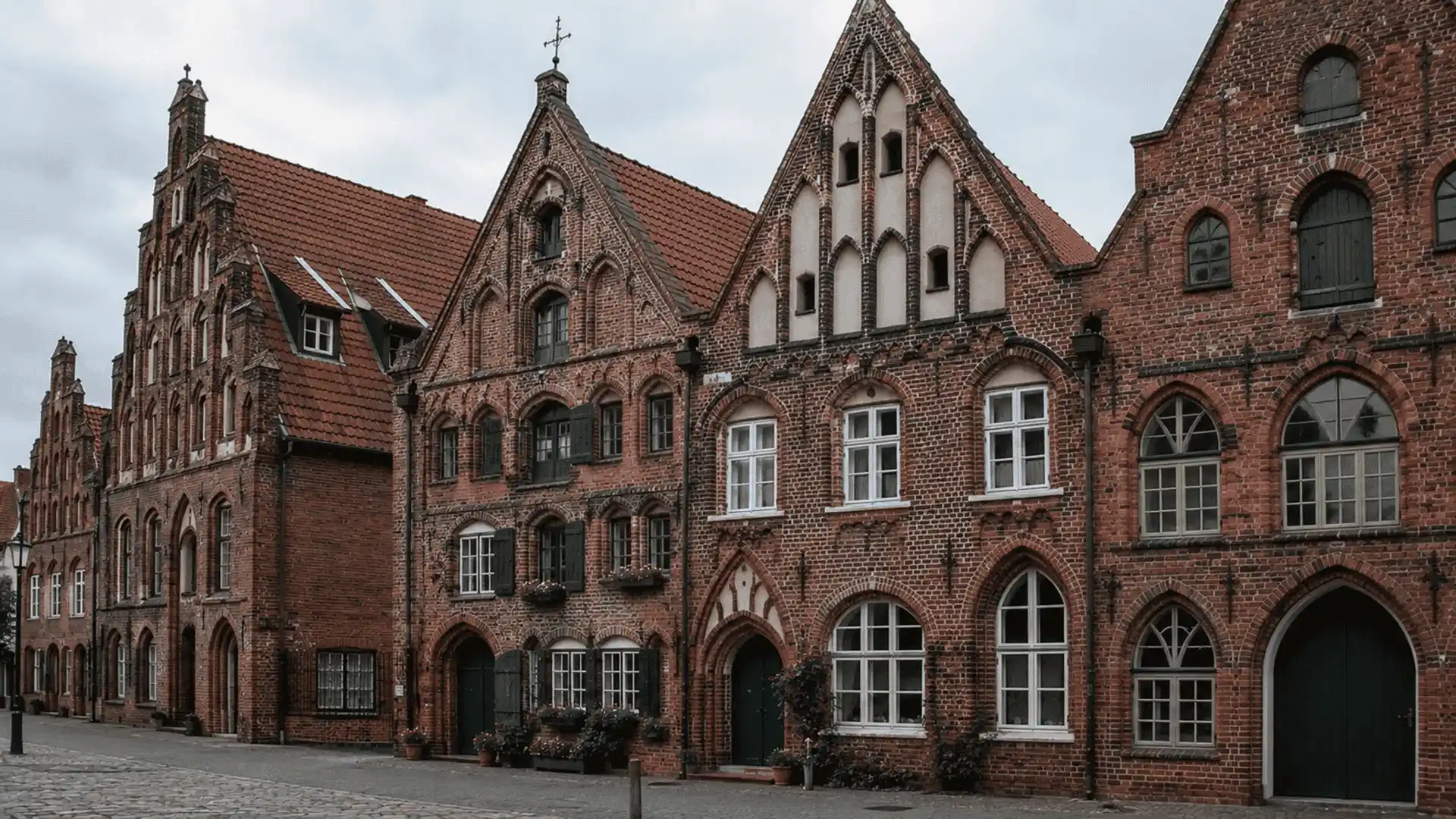 red brick gothic gabled houses with stepped facades along a cobblestone street