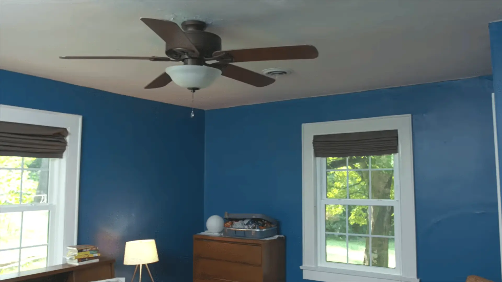 worker placing crown molding against ceiling while planning inside outside and scarf joint cuts before installation