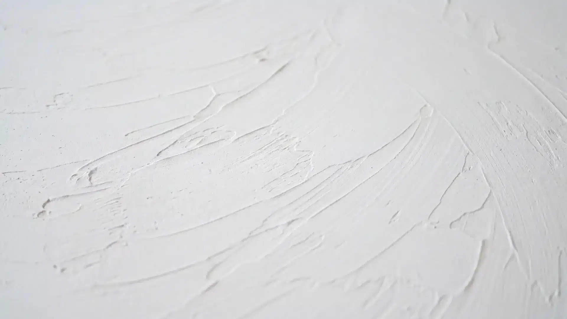 trowel ceiling texture with broad sweeping directional strokes of joint compound on white surface