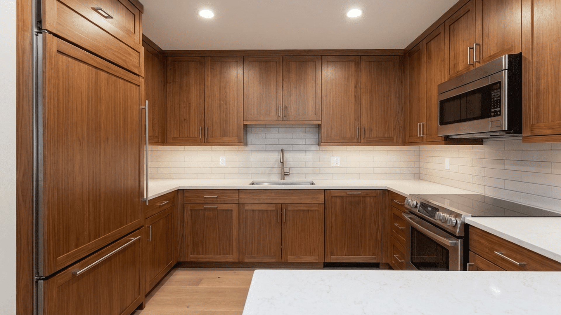 U-shaped kitchen with concealed appliances behind matching cabinet panels.