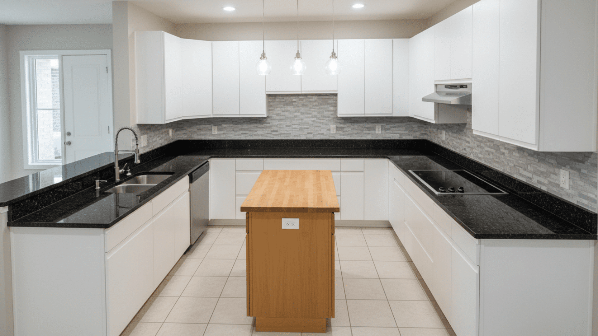 U-shaped kitchen with contrasting dark countertops and light cabinets for depth.
