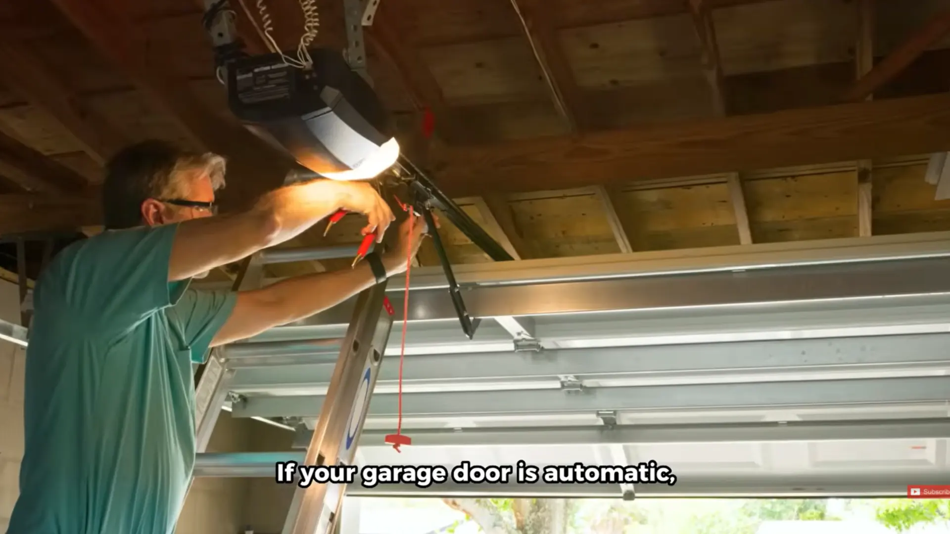 man pressure washing a dark garage door to clean the surface before painting