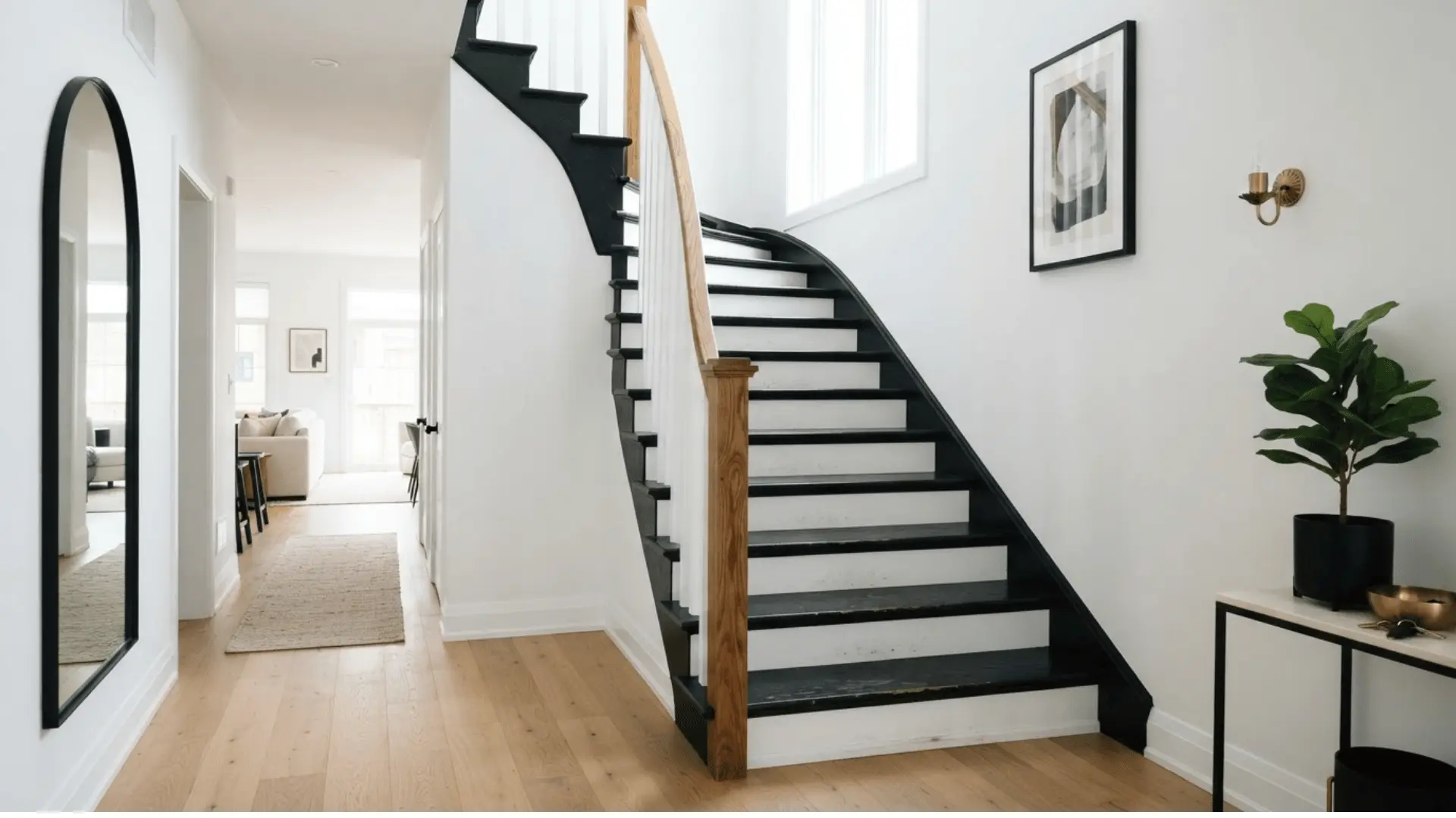 white stair risers with dark painted treads in a classic entryway with warm wood floors