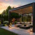 Modern outdoor patio with cozy seating area under pergola at sunset, surrounded by garden landscaping