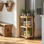Wooden kitchen storage with glass jars and plants beside stainless steel refrigerator