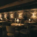 dimly lit dining room at chelsea living room nyc with candlelit tables and floral wallpaper