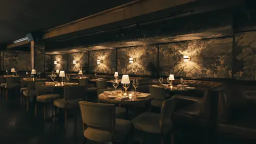 dimly lit dining room at chelsea living room nyc with candlelit tables and floral wallpaper