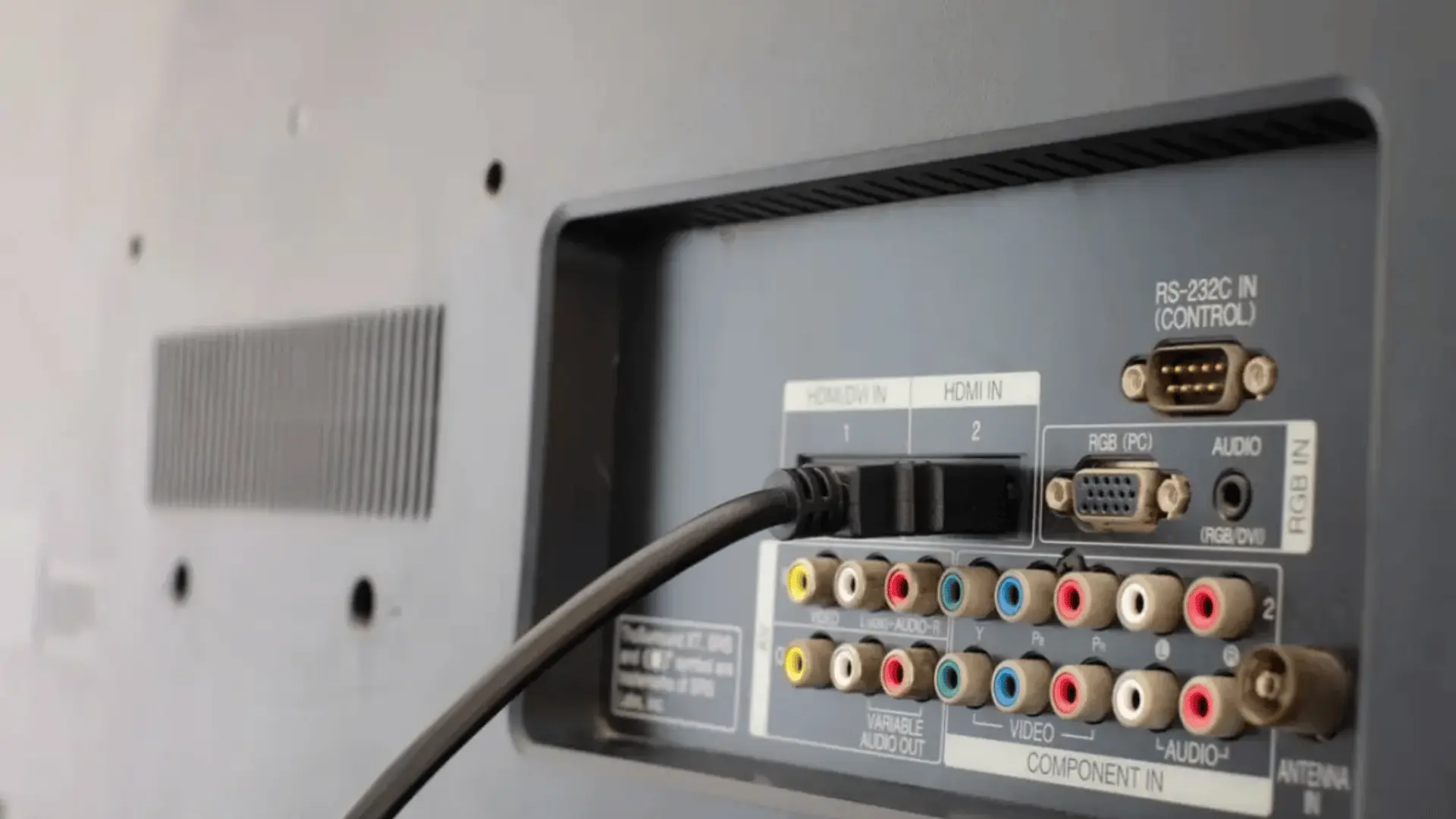 hdmi cable connected to the rear input panel of a television