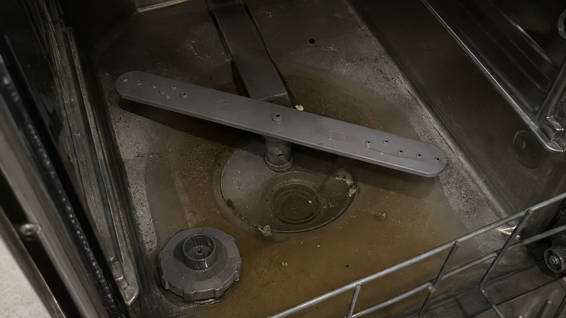 small amount of water sitting at the bottom of a dishwasher below the correct filling level