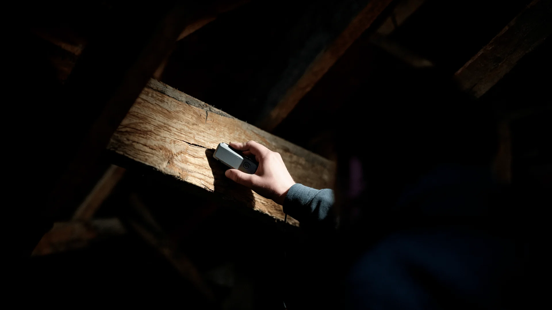 homeowner listening near a ceiling joint for faint termite activity