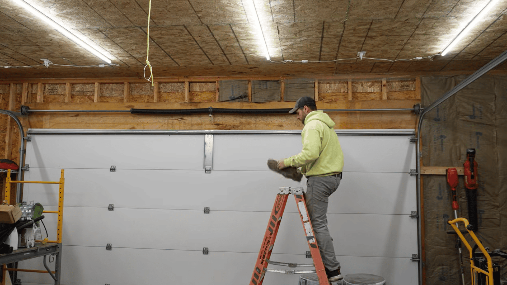 homeowner checking finished garage wall and ceiling insulation for gaps compression and blocked vents