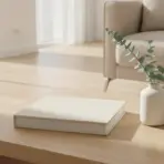 Coffee table with book, eucalyptus in vase, and candle in bright living room