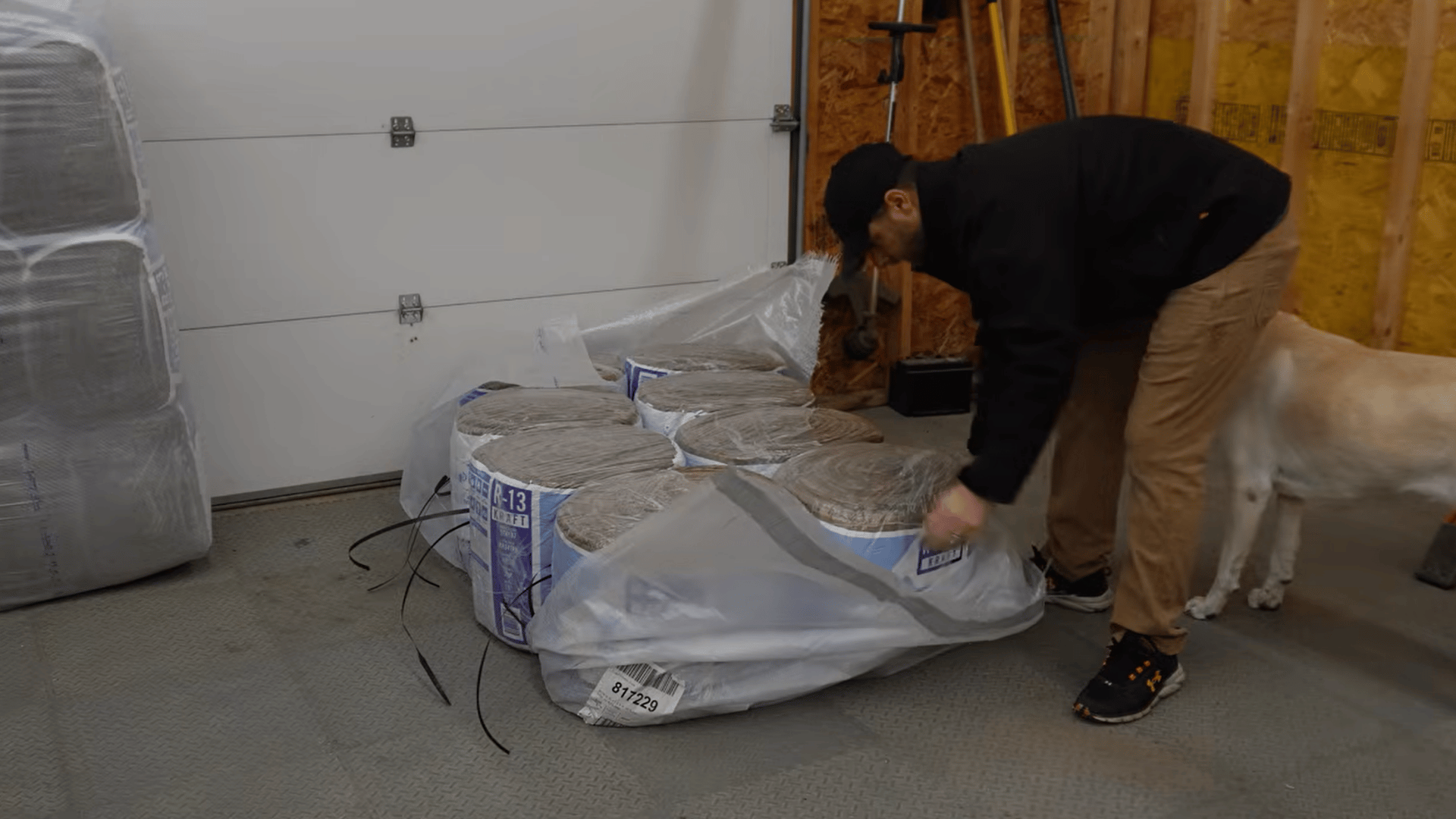 man preparing fiberglass insulation batts before installing them on a sectional garage door
