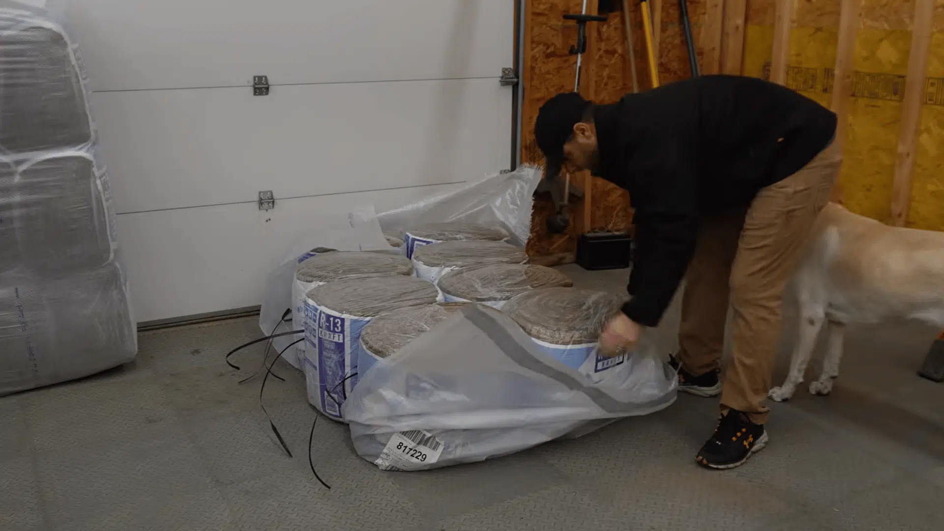 man preparing fiberglass insulation batts before installing them on a sectional garage door