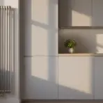 Modern kitchen with sleek cabinetry, vertical radiator, and potted plant on countertop in natural light