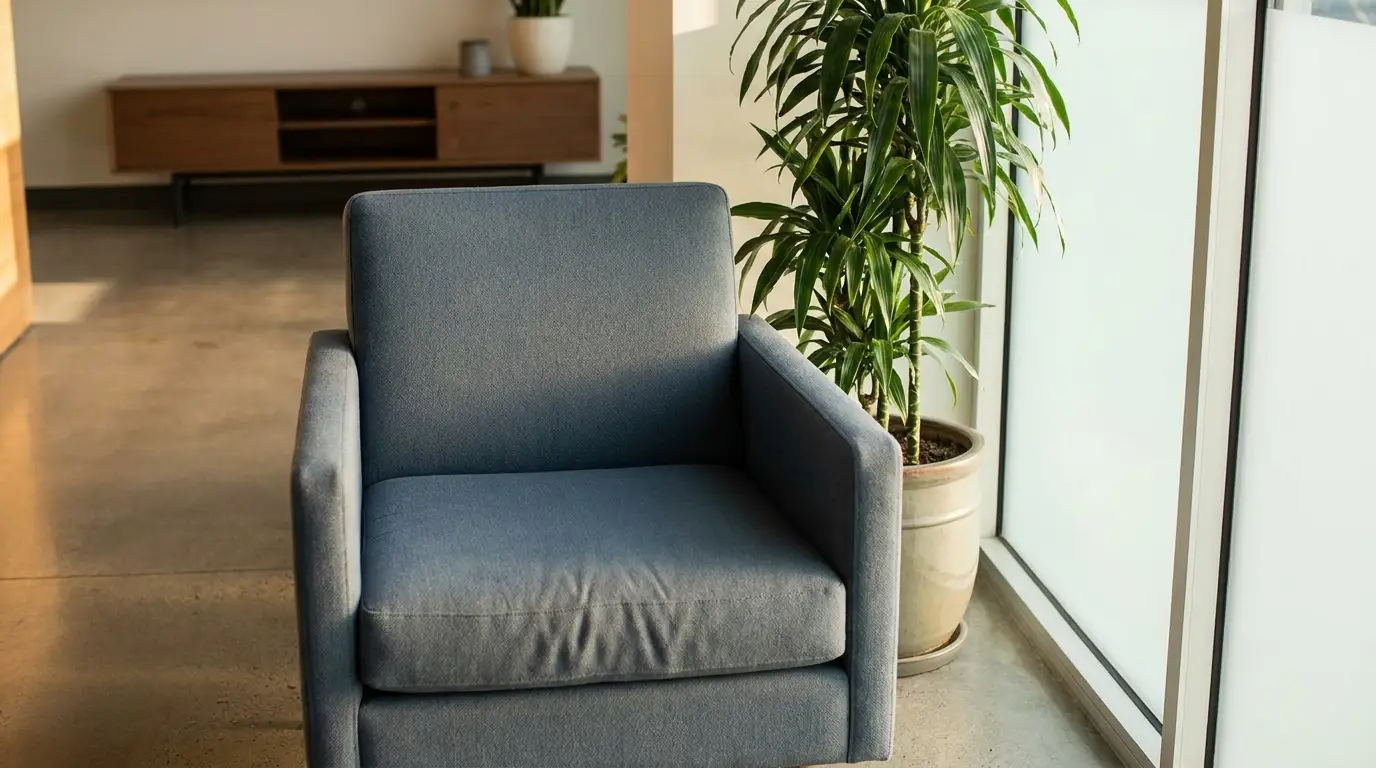 Blue armchair and potted plant near frosted window in modern living room setting