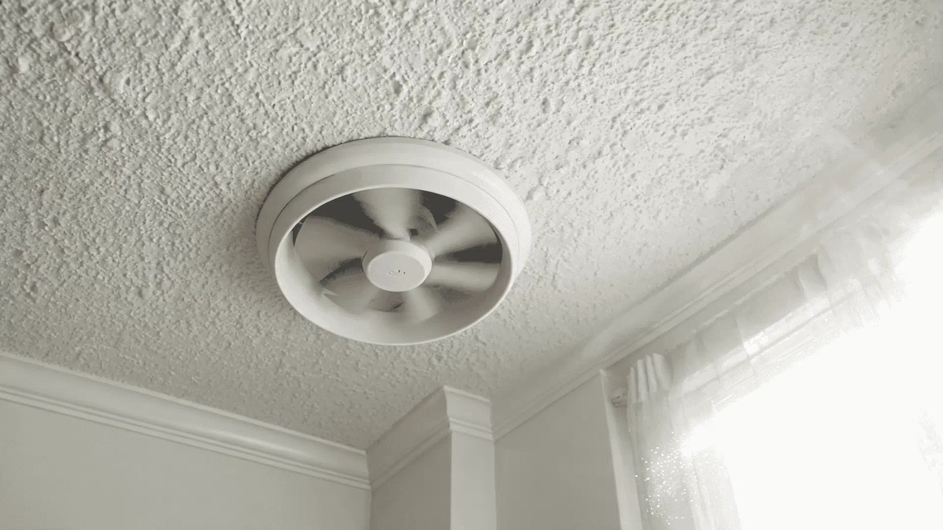 close up of an attic exhaust fan pulling hot trapped air out of a home ceiling
