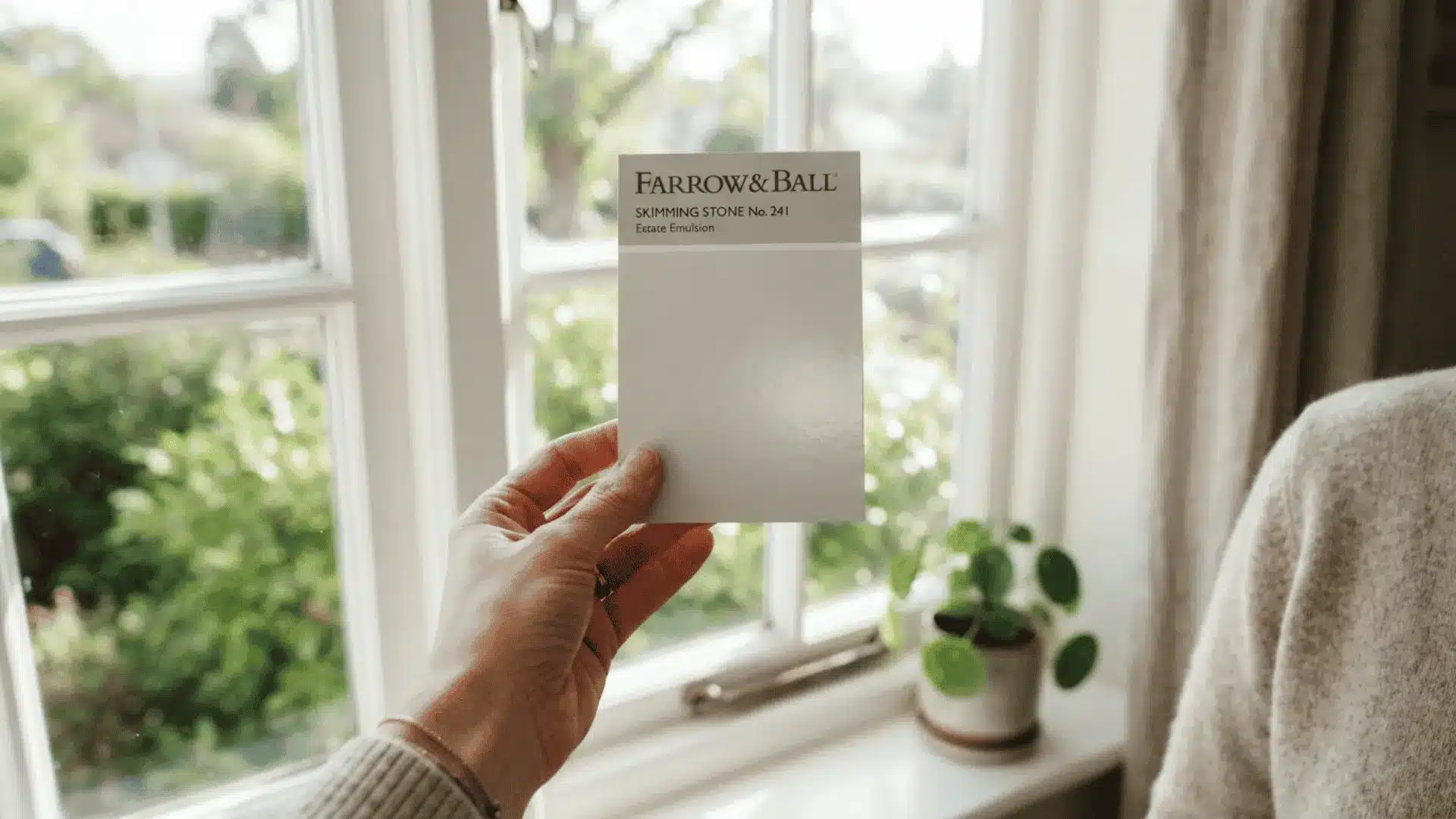 paint swatch card held near window showing light reflectance