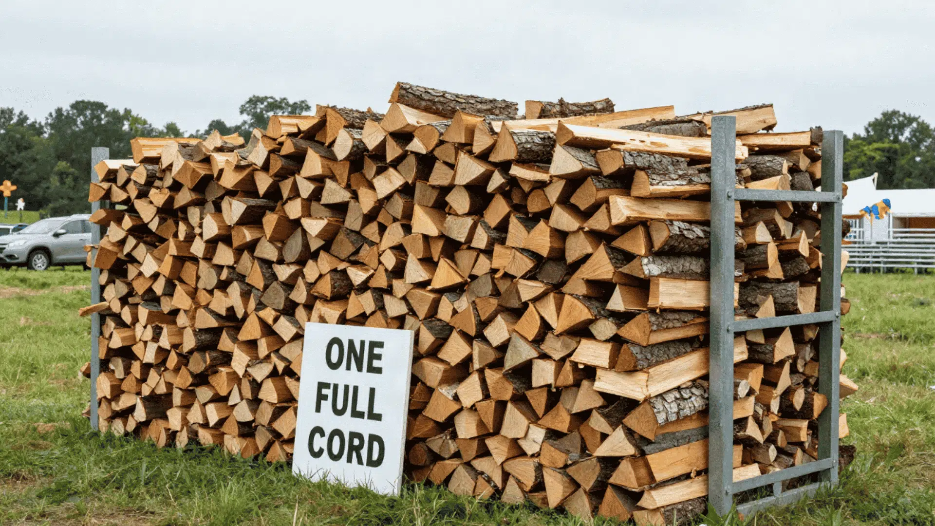 one full cord of split firewood stacked inside a metal rack with a clear sign placed in front