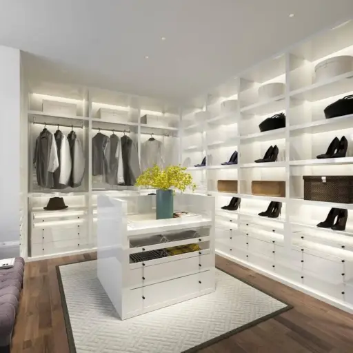 Modern walk-in closet with white shelving, clothing, and shoes, featuring a centered island and yellow flowers