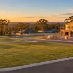 New house under construction with wooden framework in suburban area at sunset